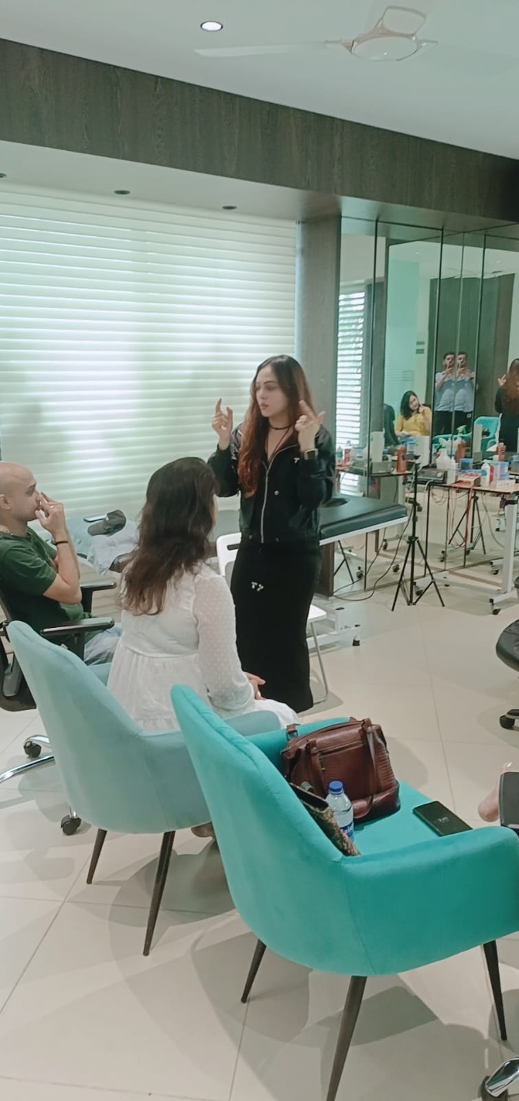 Vibha Jain standing and explaining an exercise to seated participants during a session.
